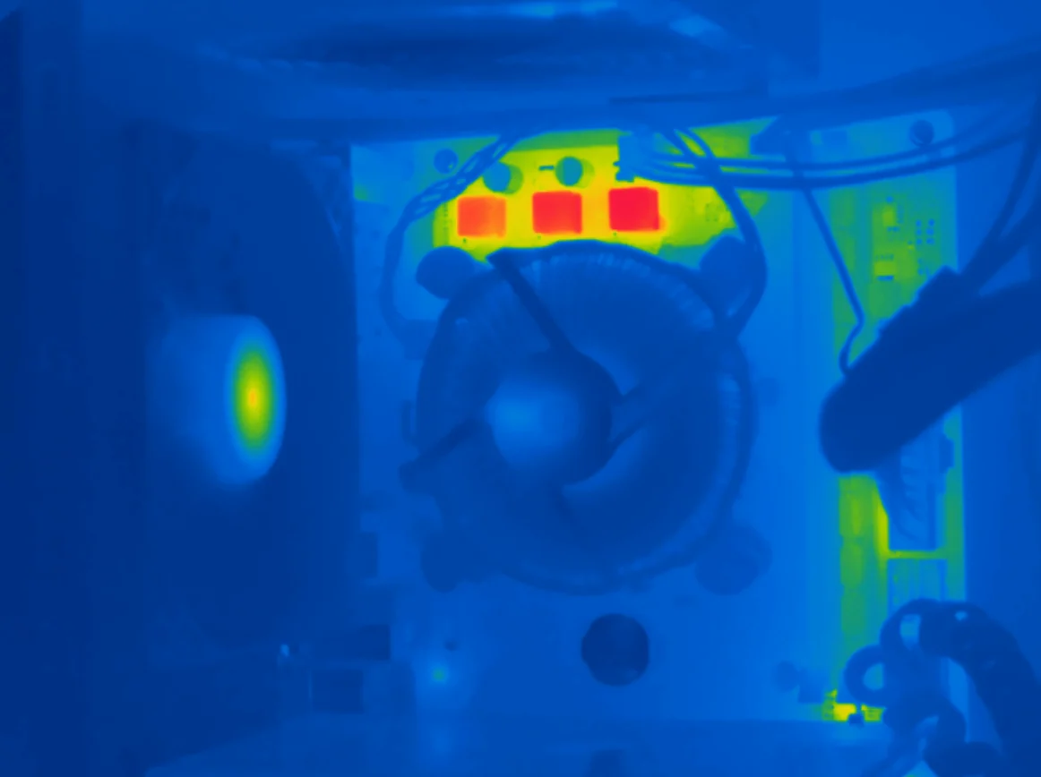 Imagem térmica em paleta arco-íris do interior de um computador, com três componentes aquecidos em vermelho acima do cooler