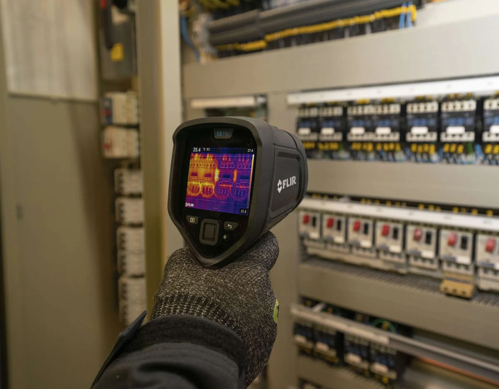Câmera termográfica FLIR E8-PRO apontada para um painel de comando, com a imagem térmica e a barra de escala na tela